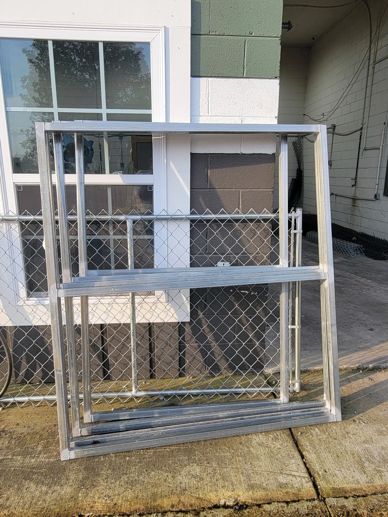 Custom 2-inch square steel tubing gate frame fabricated by Hooks Fence Company for a heavy-duty wood gate upgrade