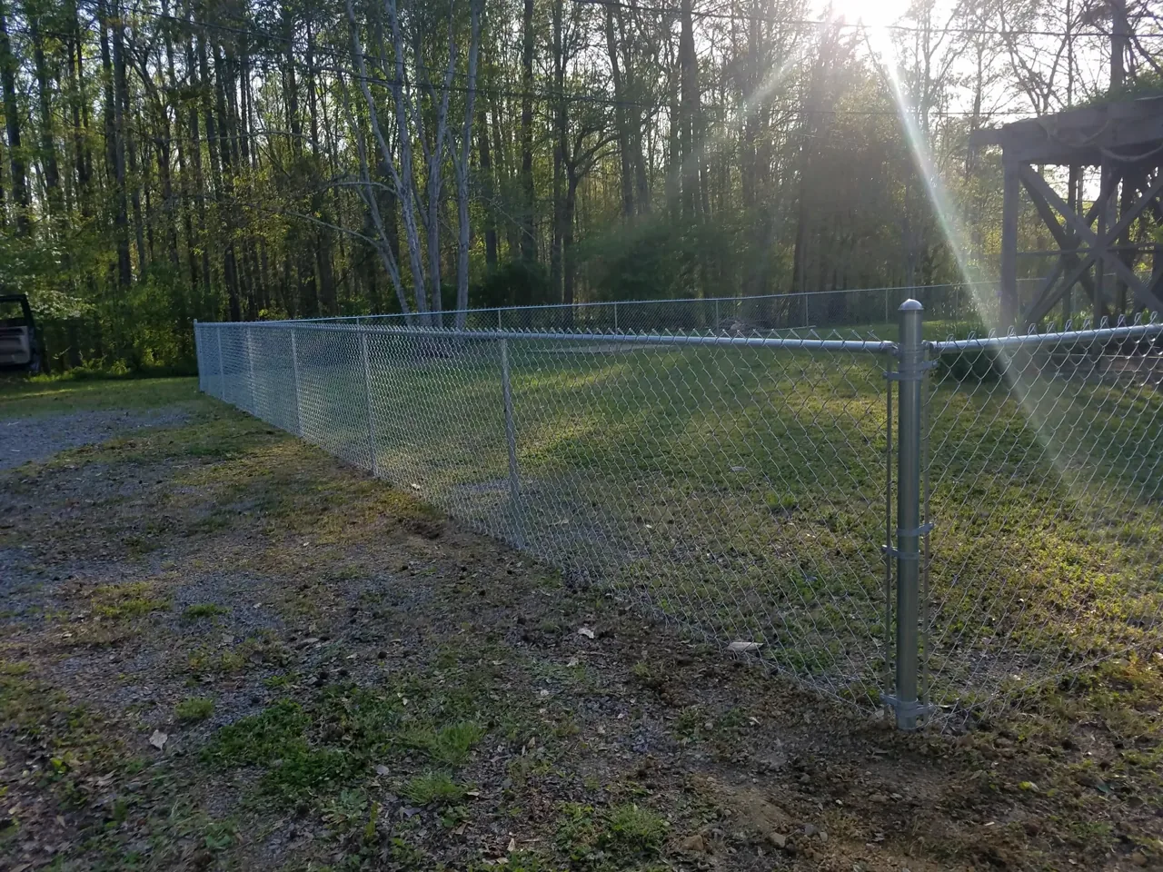 Black chain-link gate installed beside a residential deck in Carlisle Alabama