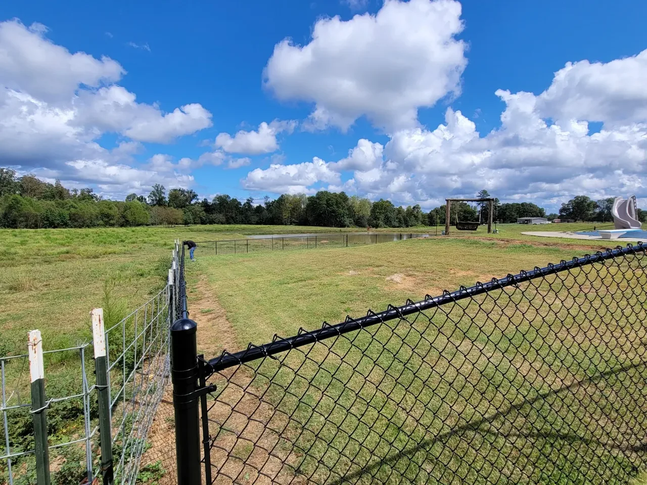 Black chain-link fence installation across a large residential property in Sardis City Alabama