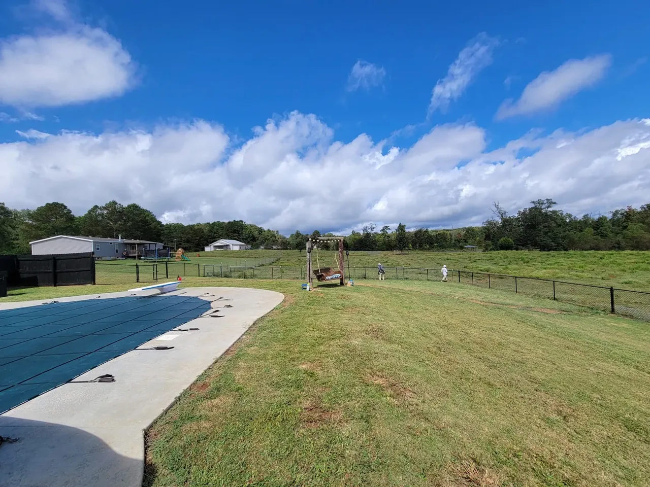 Black chain-link fence across a residential property with a pool in Sardis City Alabama