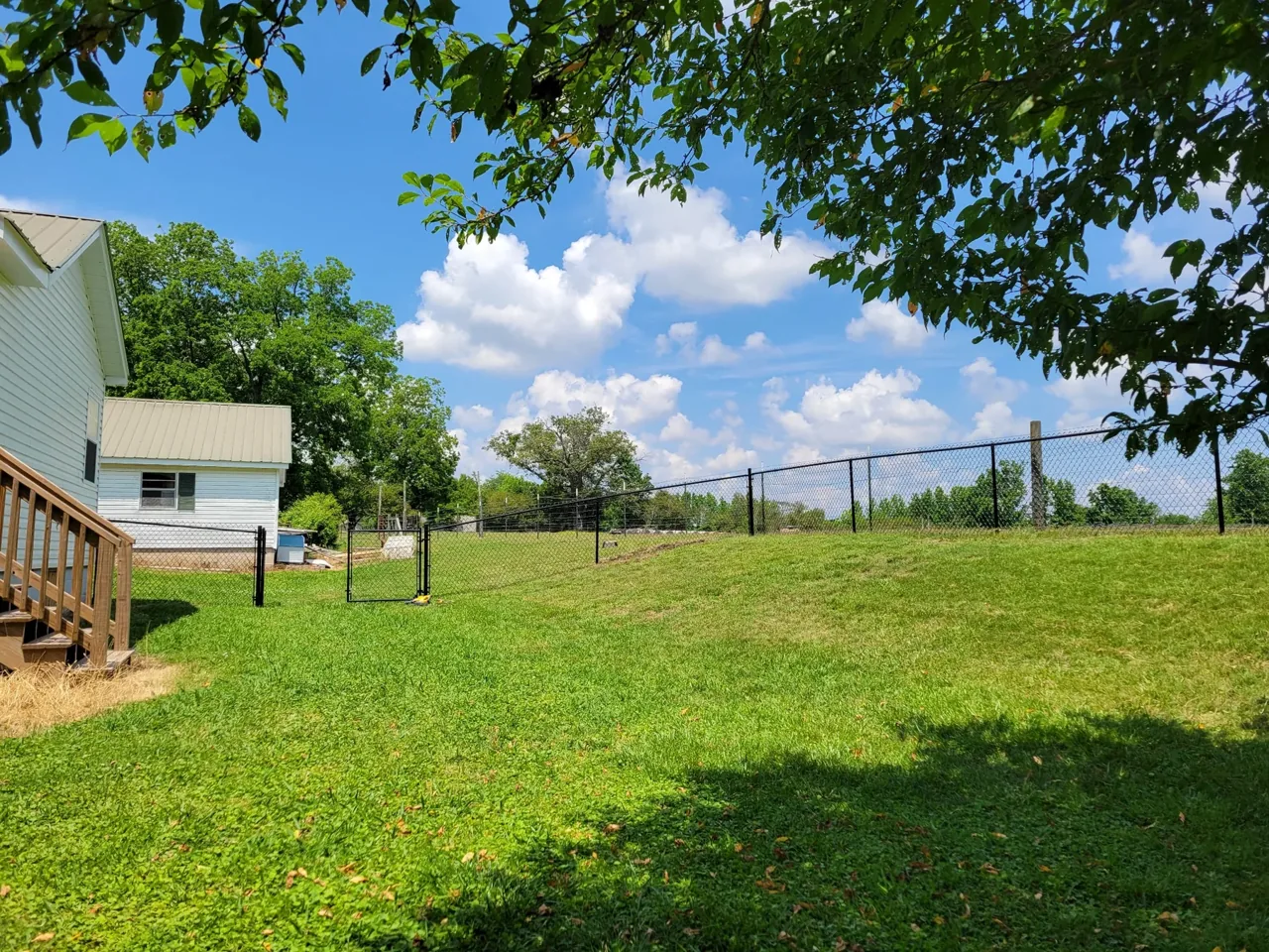 Black chain-link fence installed on sloped uneven property in Ashville Alabama