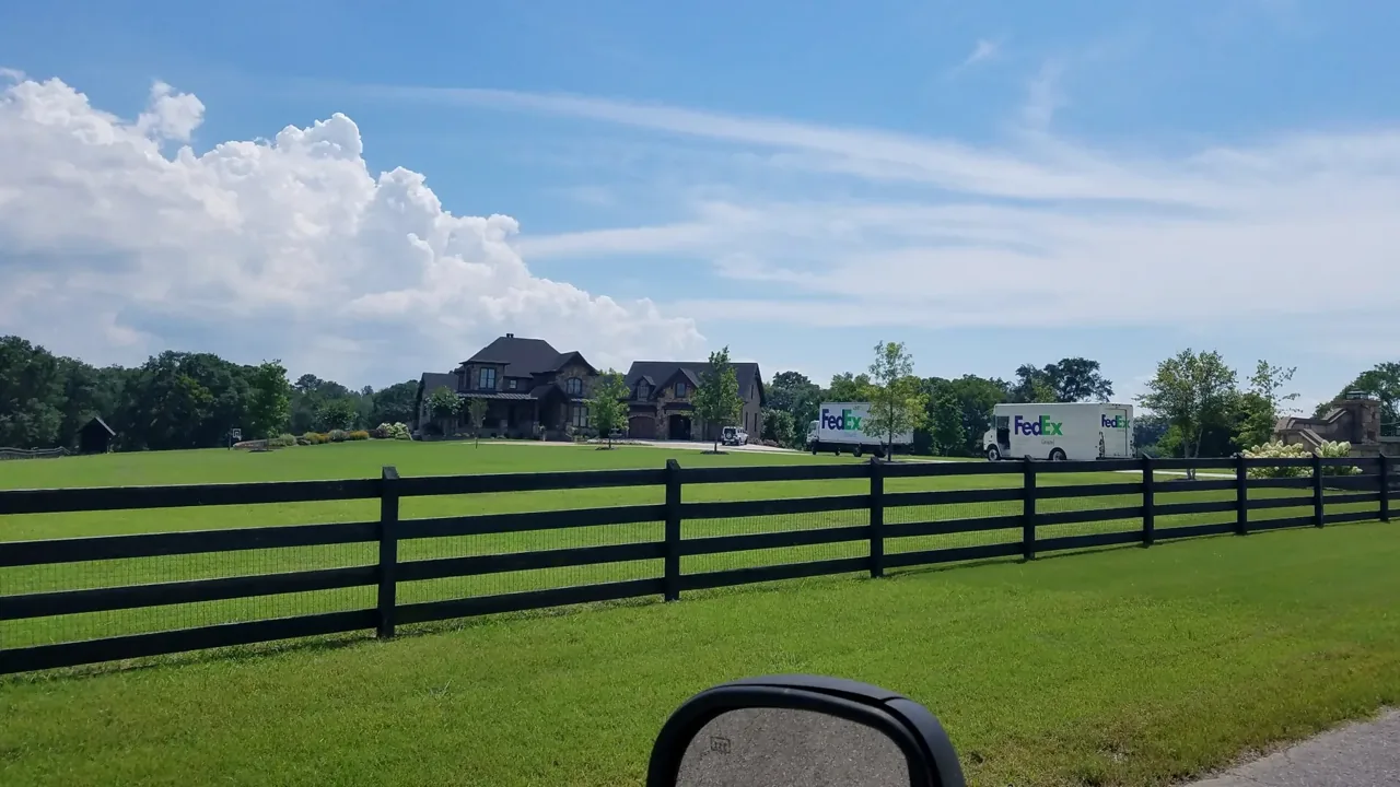 Black four rail ranch fence with wire mesh in Albertville Alabama by Hooks Fence Company