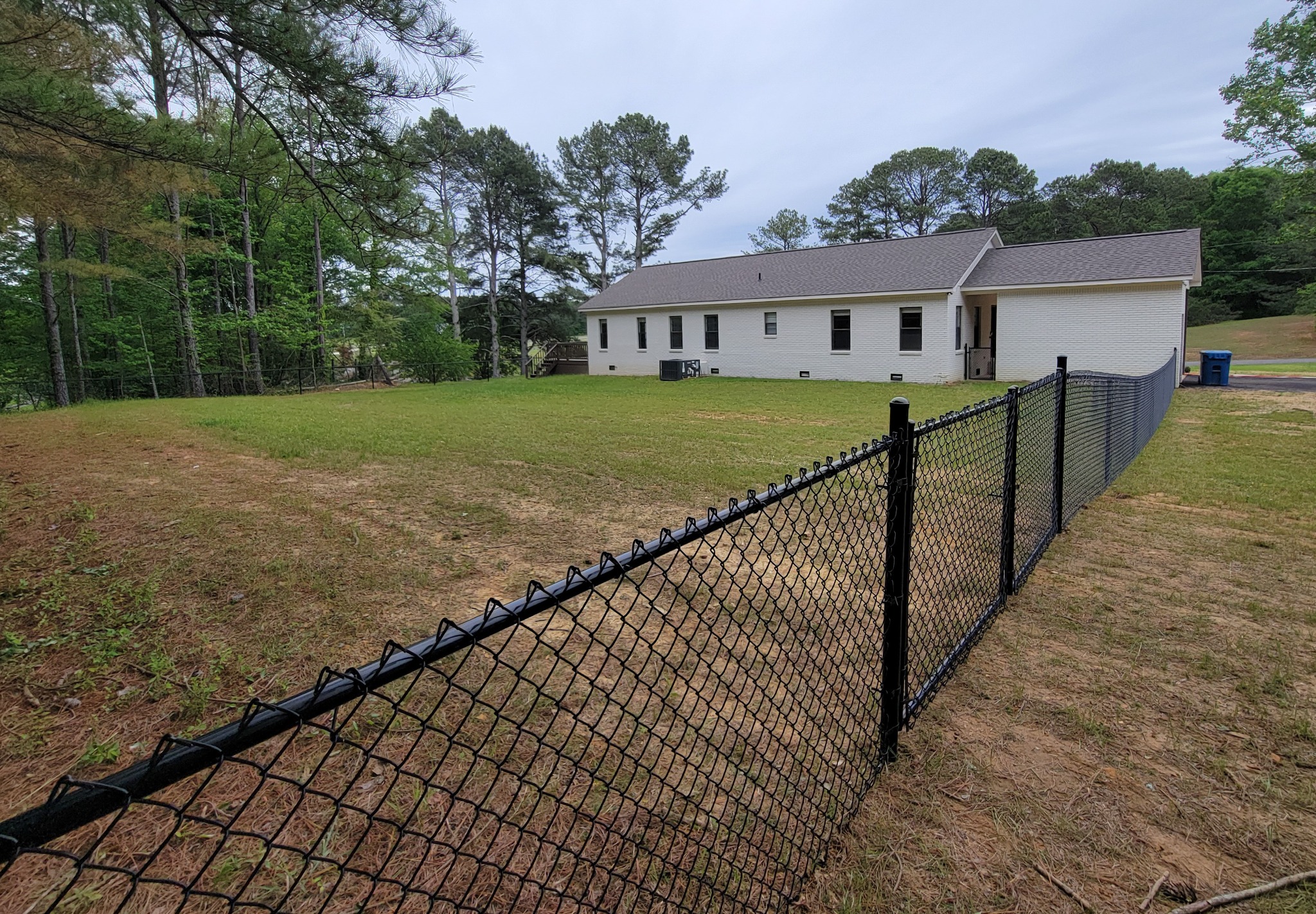 Black vinyl-coated chain-link fence in Arab, Alabama installed by Hooks Fence Company
