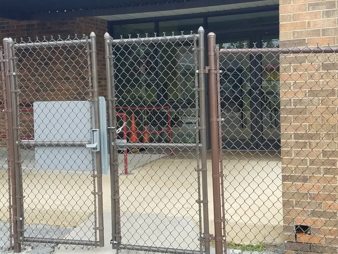 Chain-link school security fence with controlled-access gate and panic-bar exit installed by Hooks Fence Company in Guntersville Alabama